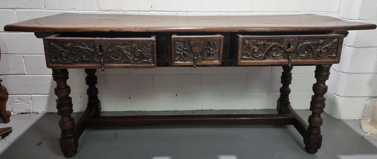 Rare and Charming 17th Century Spanish Walnut serving / side table. It has an incredible one piece walnut top with amazing character and colour. The base displays the original patina aswell as three drawers with carving and remnants of original locks. Superbly turned legs terminating on a stretcher base. Could be used as a large entrance console table, a side table or in a dining area as a serving table. In good original detailed condition especially considering its age.