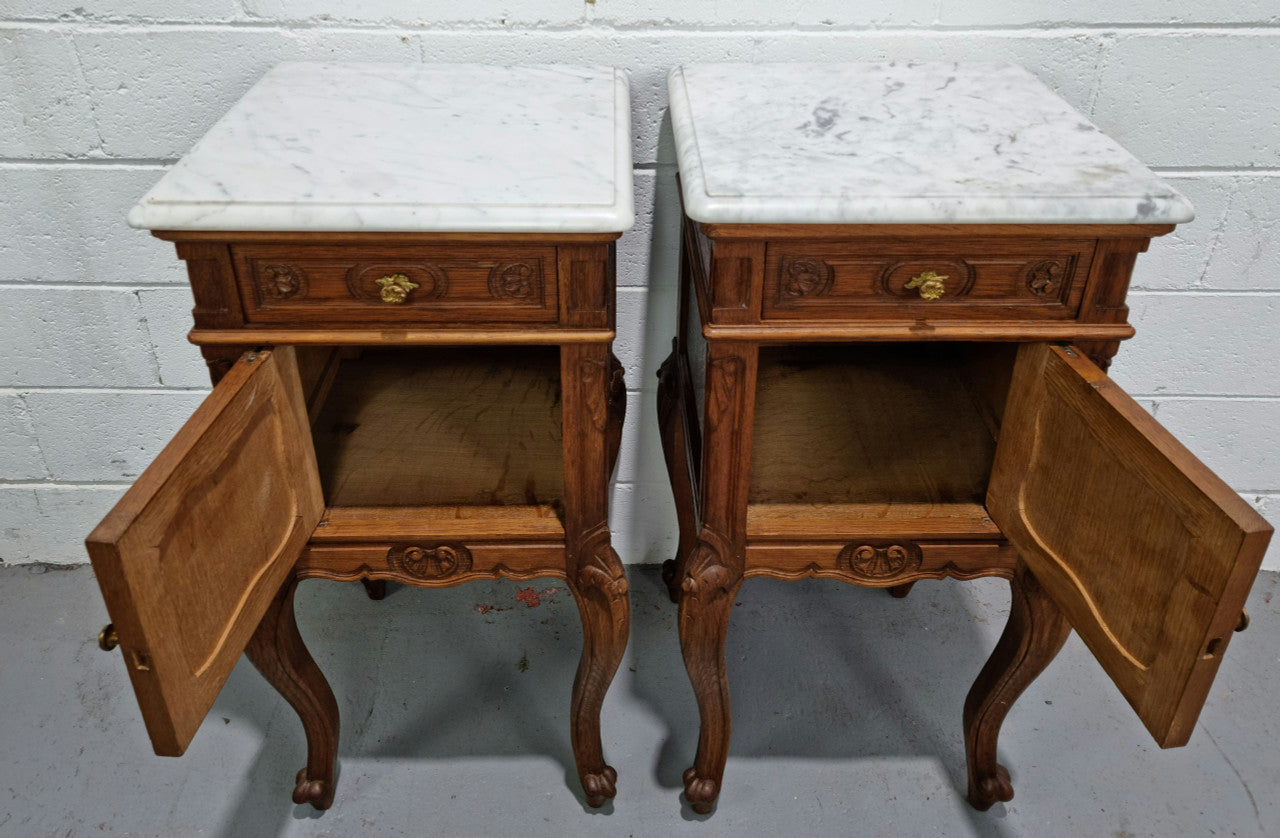 Lovely pair of French Oak carved Louis XV style bedside cabinets with a white marble top, drawer and cupboard in good original detailed condition.