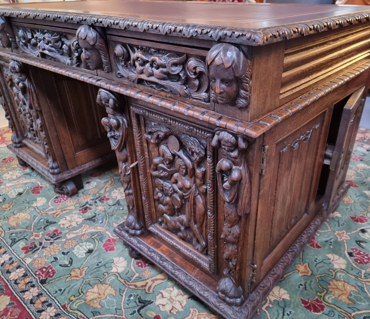 Beautifully carved French Oak early 19th century pedestal desk with 3 drawers, two cupboards and a secret cupboard on the side. There is also a lovely burgundy tooled leather top. In good original detailed condition.