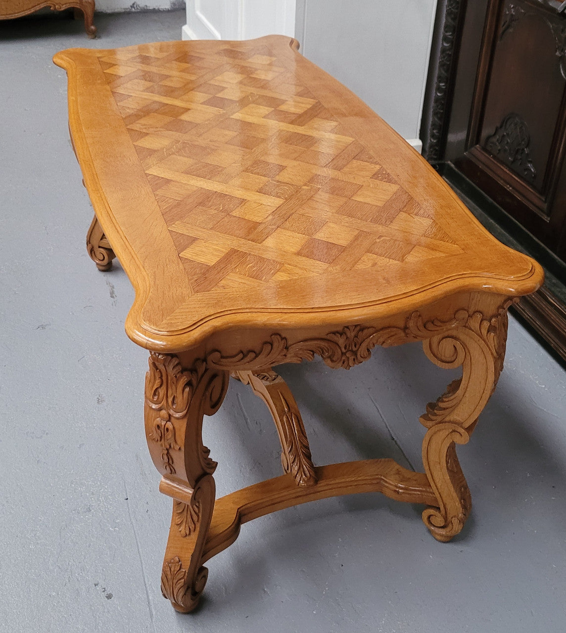 French Oak parquetry top coffee table with decorative carved base. It is in good original detailed condition.
