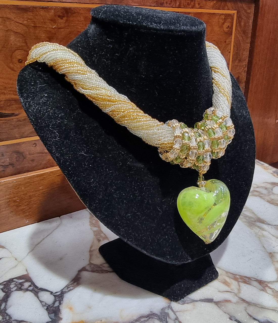 Hand Made Murano glass multi string small glass beads with medium glass beads and a large puff heart in neutral and green shades with gold. In original box.