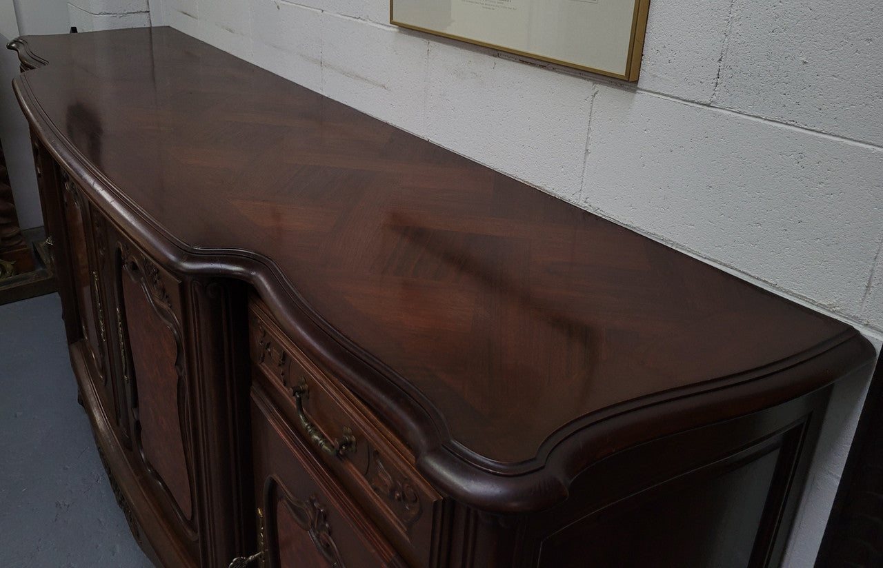 Fabulous Louis XV style French Walnut and Burr Walnut four door sideboard. Each door panel has beautiful Burr Walnut panels and open up to an adjustable shelf. Beautiful handles and two drawers for added storage. In good original detailed condition.