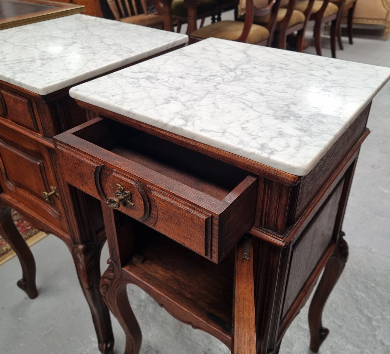 Elegant French Louis XV style pair of carved Oak white marble top bedsides. They are in good original condition and they have been detailed to a high standard. They have been sourced from France.