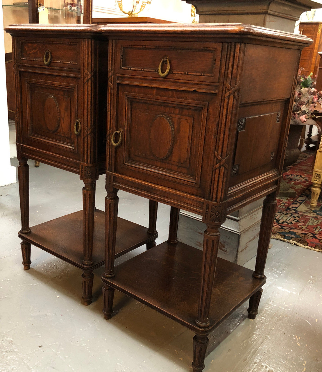 Lovely pair of French Oak Louis XVI style bedside cabinets with inset marble tops a drawer and a cupboard for storage. In good original detailed condition.