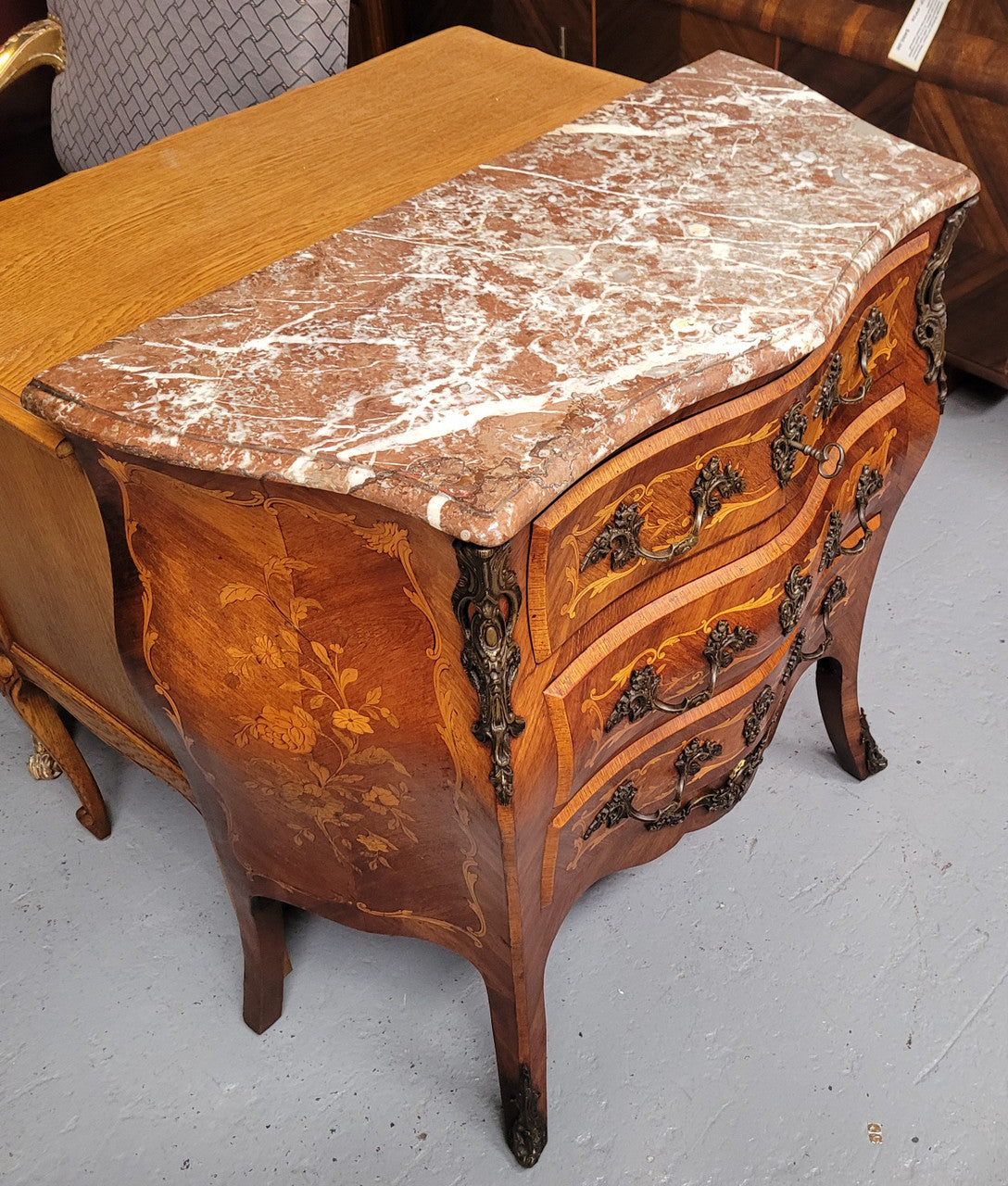 Antique French Louis XV style compact three drawer marble top commode with marquetry inlay and ormolu mounts. Sourced from France and in good original detailed condition.