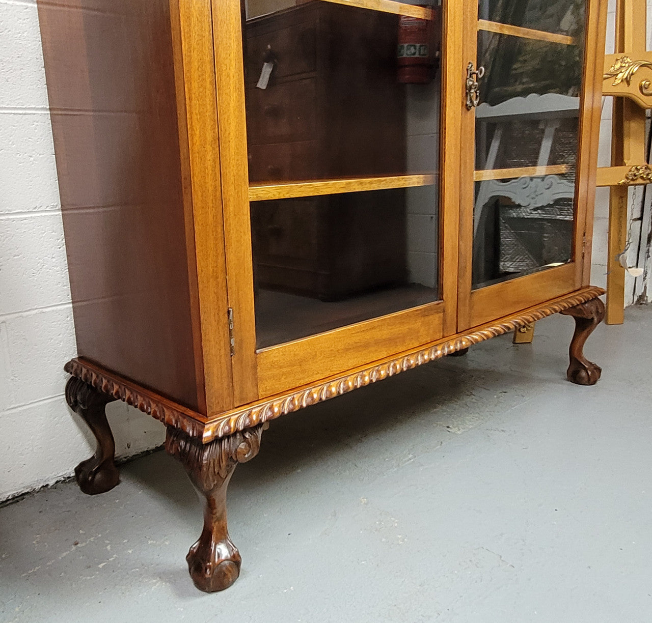 Chippendale style Mahogany two door bookcase. It has bevelled glass doors and two adjustable shelves. It has been sourced locally and is in good original detailed condition.