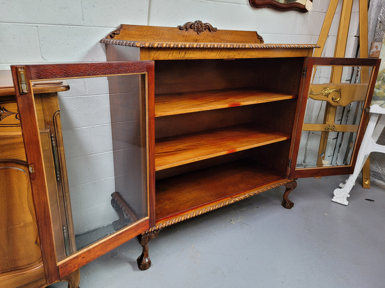 Chippendale style Mahogany two door bookcase. It has bevelled glass doors and two adjustable shelves. It has been sourced locally and is in good original detailed condition.