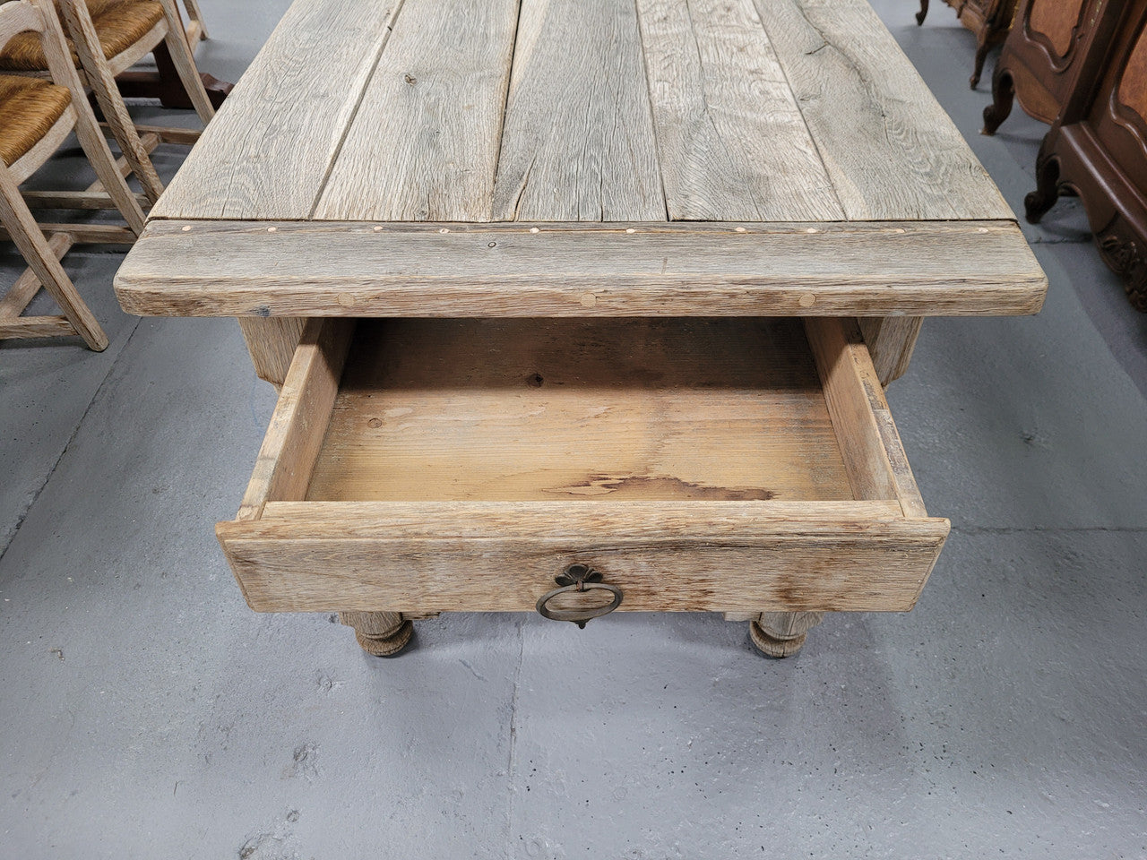 French stripped Oak pedestal stretcher base Farmhouse table with two drawers on either side of table. Features raw wood that could be used as is for a distressed look, or finished and waxed for a more refined look.
