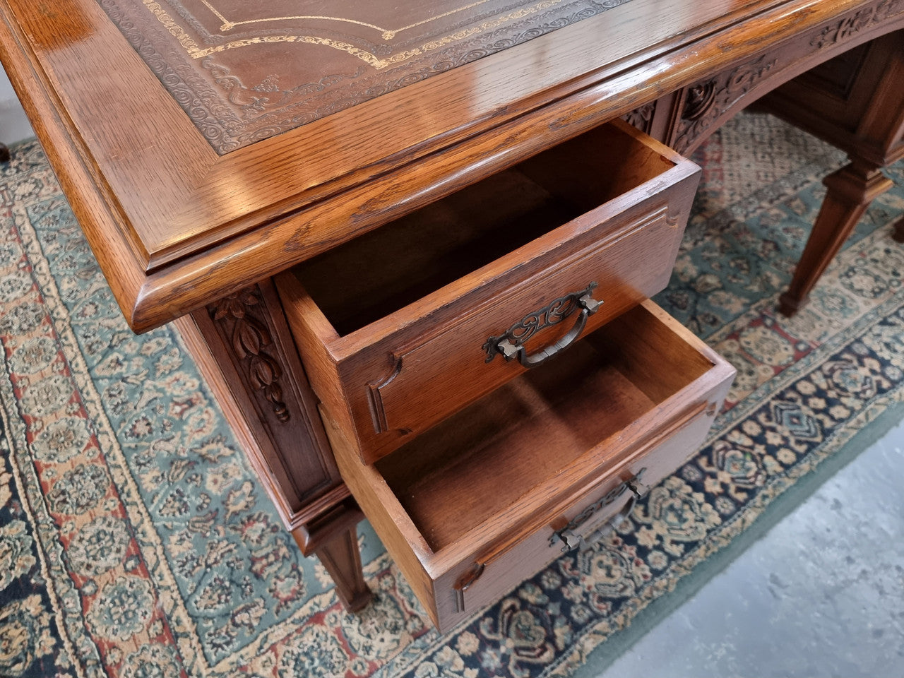 Substantial French Louis XVI style Oak partners desk. It has a beautiful leather top, two drawers on either side and decorative carvings throughout. Sourced from France and in good original detailed condition.