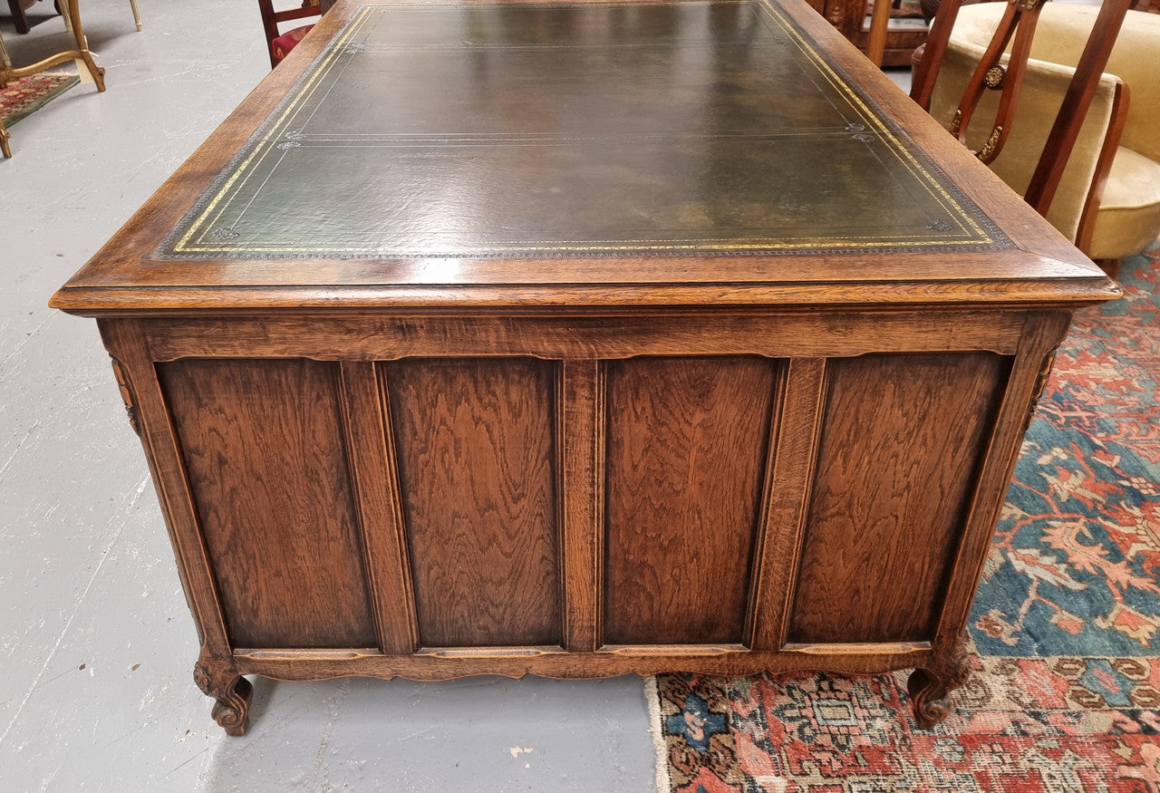 Fabulous Louis XV style French Oak beautifully carved full partners desk with an amazing tooled leather top. Both sides have a functioning drawer in the middle and two cupboards either side. On both sides one cupboard door opens up to four smaller internal drawers. Plenty of storage space and a large top surface to work on. It is in good original detailed condition.