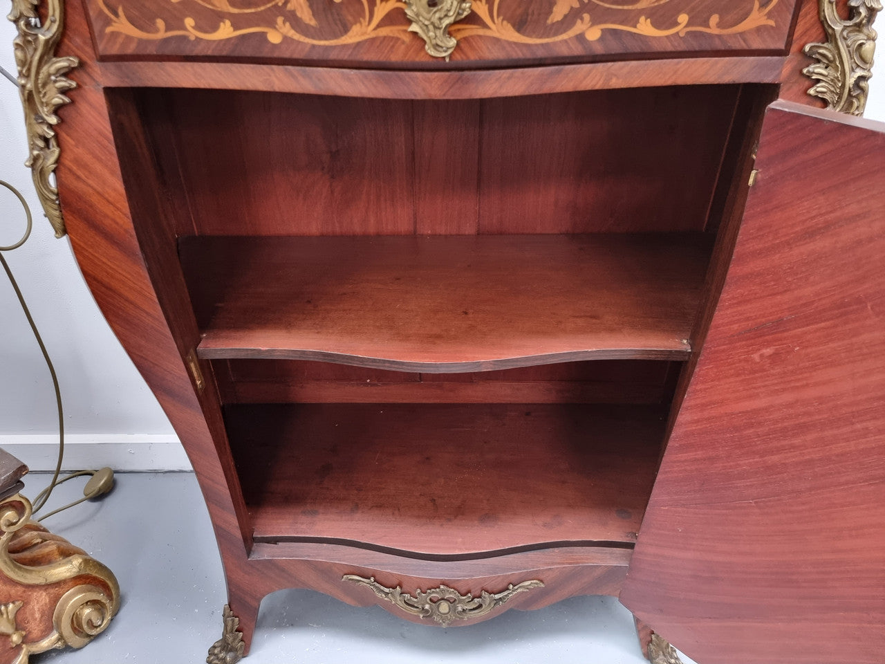 Stunning French Transitional style Mahogany marquetry inlay salon cabinet in the bombe shape. It has one draw, one shelf, marble top & ormolu decoration. Sourced from France and in good original detailed condition.