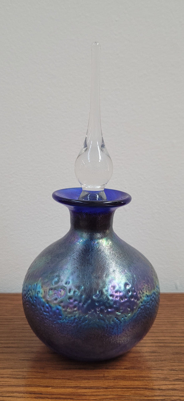 Stunning iridescent hand blown perfume bottle. Beautiful peacock blue, purple colours. Signed on base with clear glass stopper.