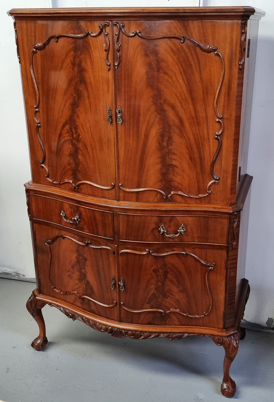1950’s Chippendale Style Flame Mahogany Four door Bar. The top section has glass shelves and a mirrored pull out tray for storing glasses, decanters & serving etc. It also has a silver presentation plaque to the Mayor of Hawthorn 1958. The bottom section is for storage bottles etc. A stunning and practical piece.