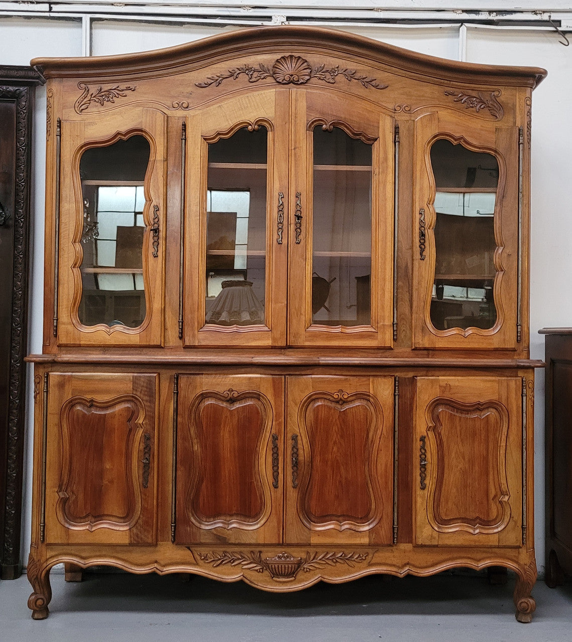 Magnificent French Walnut two-body four door display cabinet. Heaps of storage space with four glass doors at the top with shelves and four solid doors below also with shelving. It has been sourced from France and comes with a key for each door and all are lockable. In good original detailed condition.