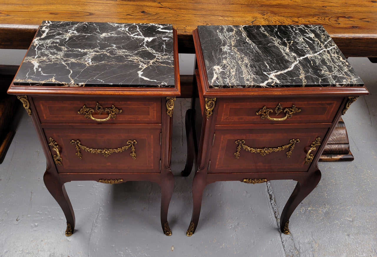 Appealing Louis XV style high quality bedside cabinets with black Portoro marble top and bronze mounts. They have been sourced from France and are in good original condition.