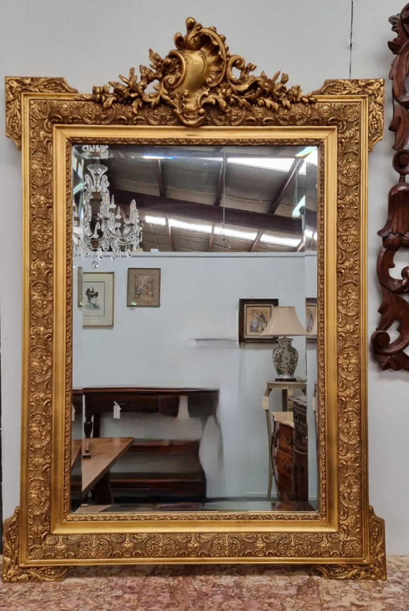 French ornate gilt decorated and floral bevelled mirror. It has been sourced from France and it is in good original condition.