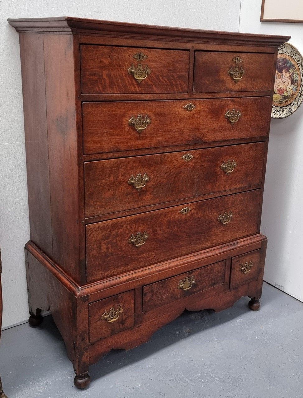 Early 19th Century English Oak chest on stand. It has been sourced in France and has plenty of storage space with eight drawers. In good original detailed condition.