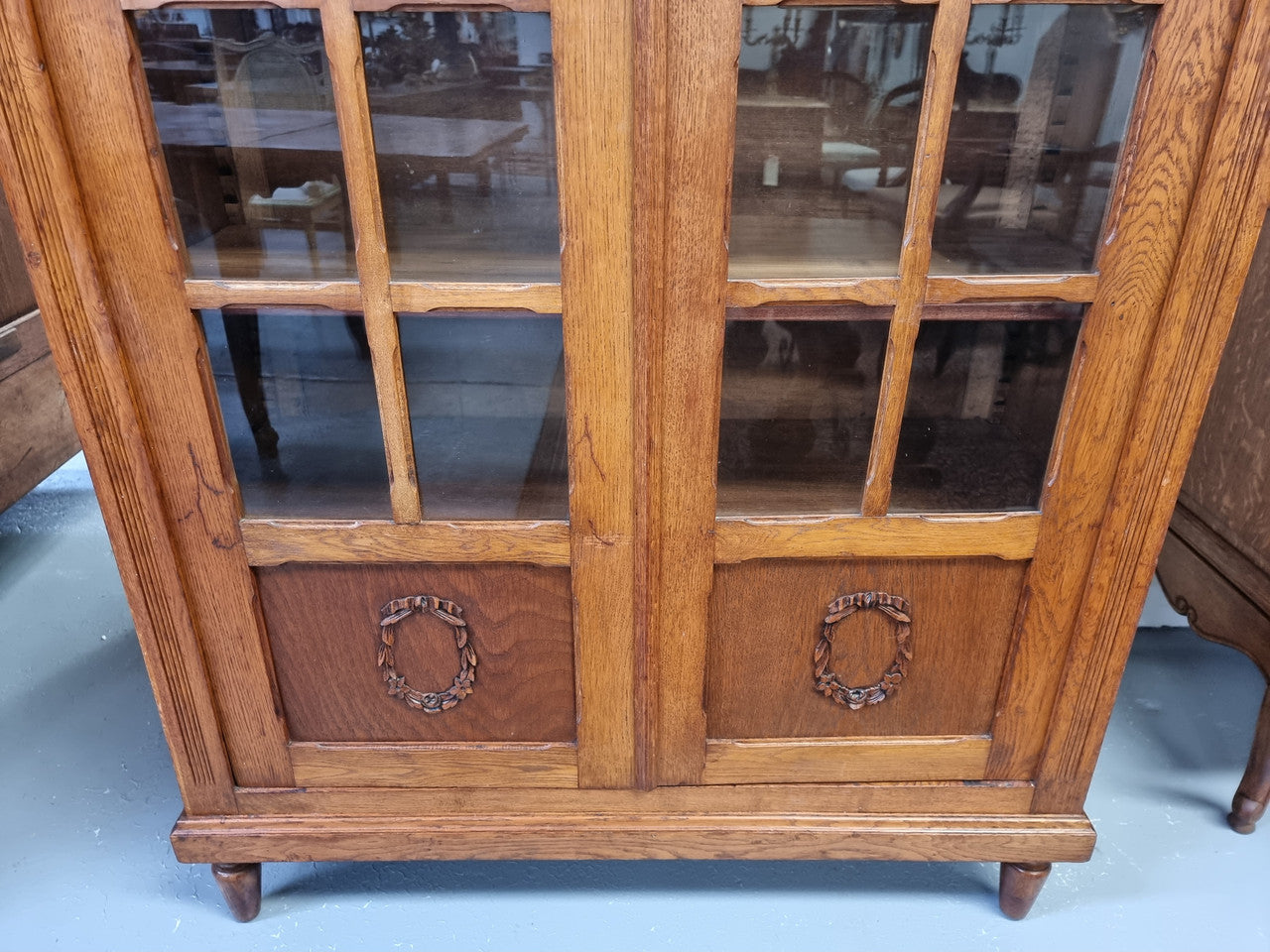French light Oak two door bookcase with four adjustable shelves. It has beautiful decorative carving and is in good original detailed condition.