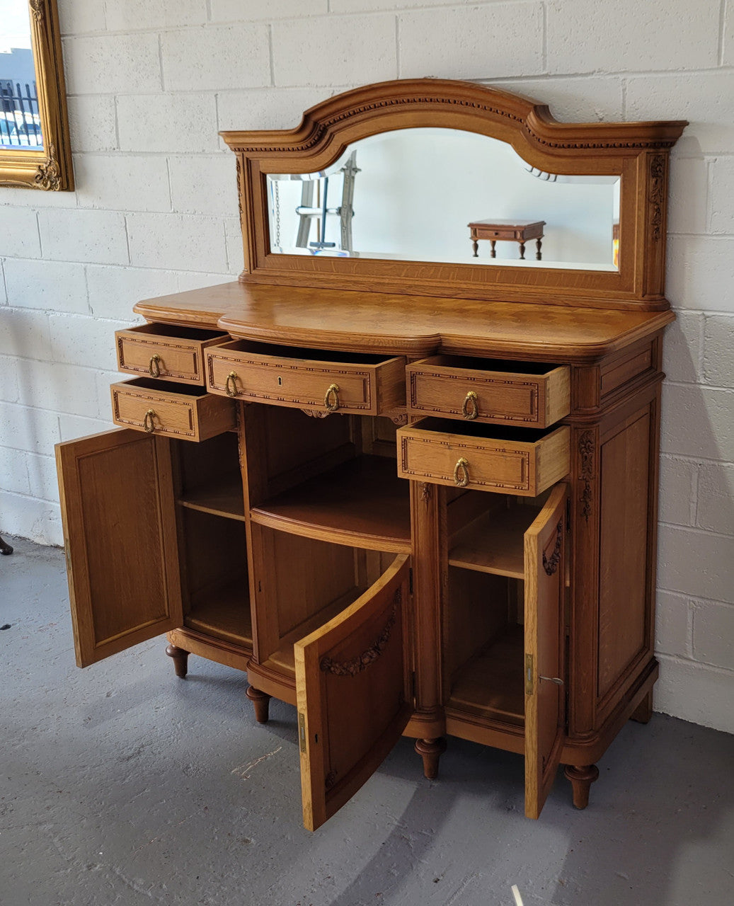 Beautiful French Oak Louis XVI Style nicely carved sideboard with a lovely parquetry top and mirror. It has five drawers and three cupboards for all your storage needs. In good original detailed condition.