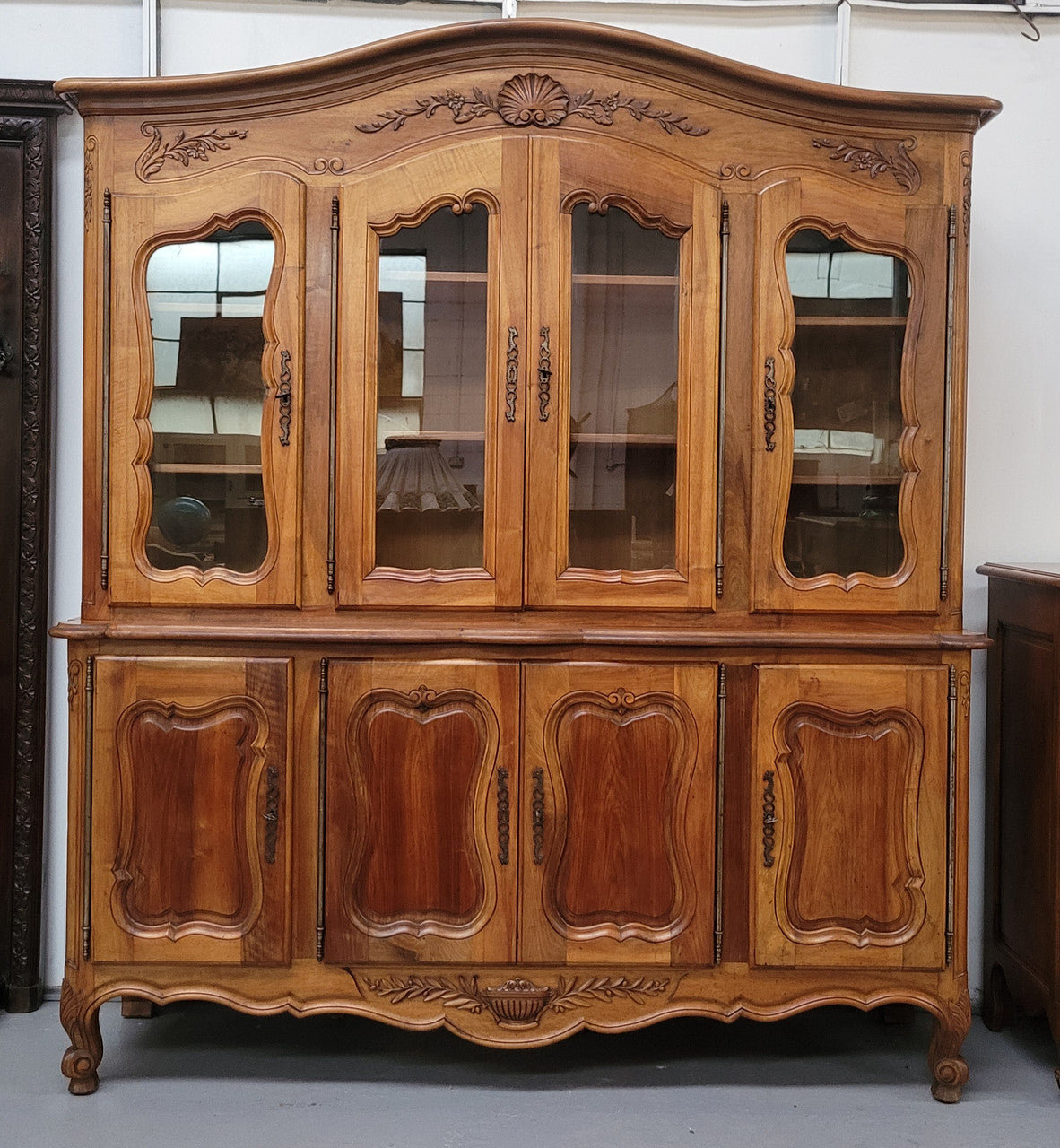 Magnificent French Walnut two-body four door display cabinet. Heaps of storage space with four glass doors at the top with shelves and four solid doors below also with shelving. It has been sourced from France and comes with a key for each door and all are lockable. In good original detailed condition.
