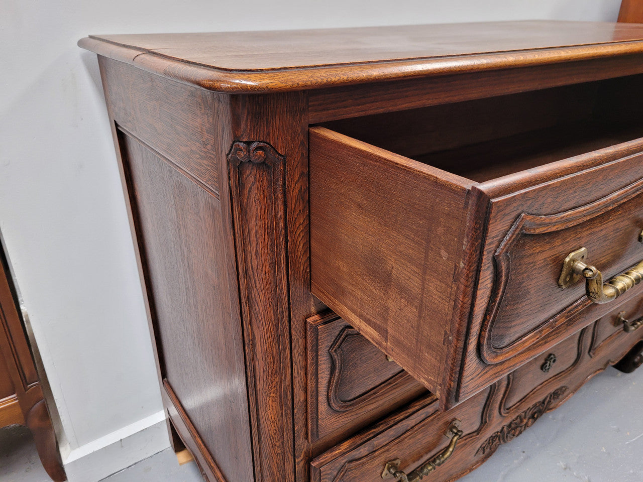 French Provincial Oak three drawer wooden top commode. It has elegant carvings and handles. It has been sourced from France and is in good original detailed condition.