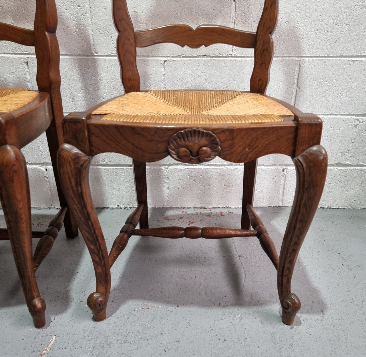 Lovely set of six French oak rush seated provincial dining chairs. They have been sourced from France and are in good detailed condition.