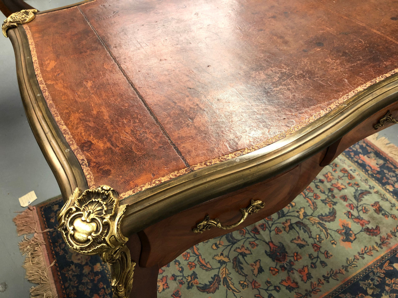 An impressive French Walnut petite Bureau Plat with superb ormolu mounts, original tooled leather top with loads of character and drawers for storage. It is in very good original detailed condition.