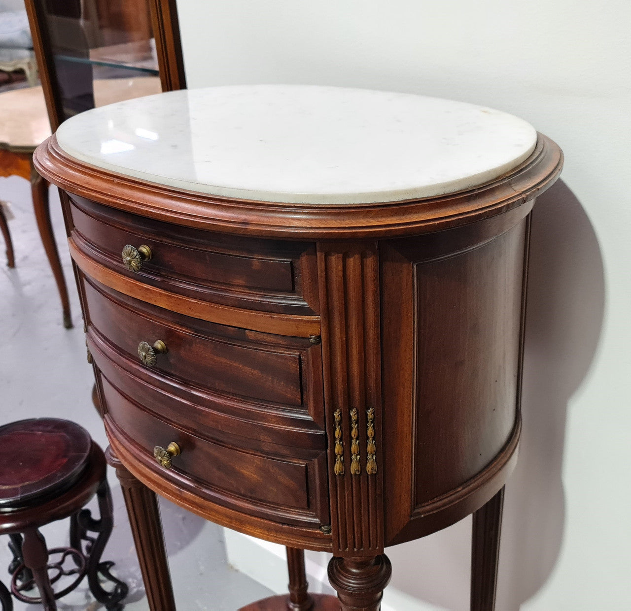 Round Louis XVI style Mahogany marble top side table. It has one drawer and a cupboard for storage. It is in good original detailed condition.