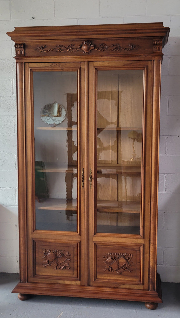 Stunning French Walnut Henry II style two door bookcase with four fully adjustable shelves. The lock on the door is functional and has a key. It is in good original detailed condition.