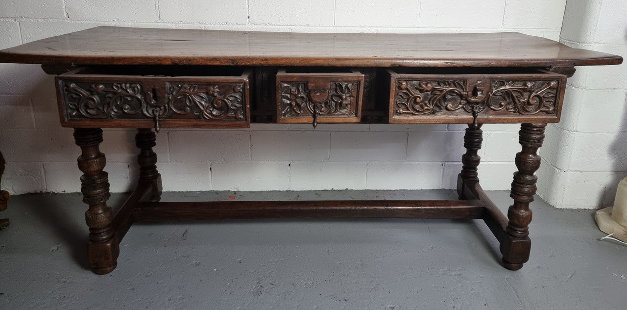 Rare and Charming 17th Century Spanish Walnut serving / side table. It has an incredible one piece walnut top with amazing character and colour. The base displays the original patina aswell as three drawers with carving and remnants of original locks. Superbly turned legs terminating on a stretcher base. Could be used as a large entrance console table, a side table or in a dining area as a serving table. In good original detailed condition especially considering its age.