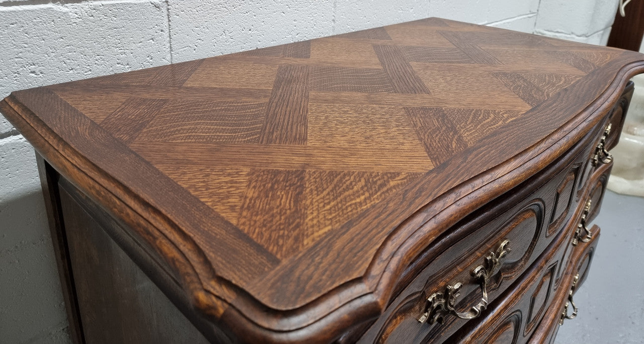 Lovely French nicely carved chest of 3 drawers with a parquetry top, with decorative handles and lovely carving. In good detailed condition.