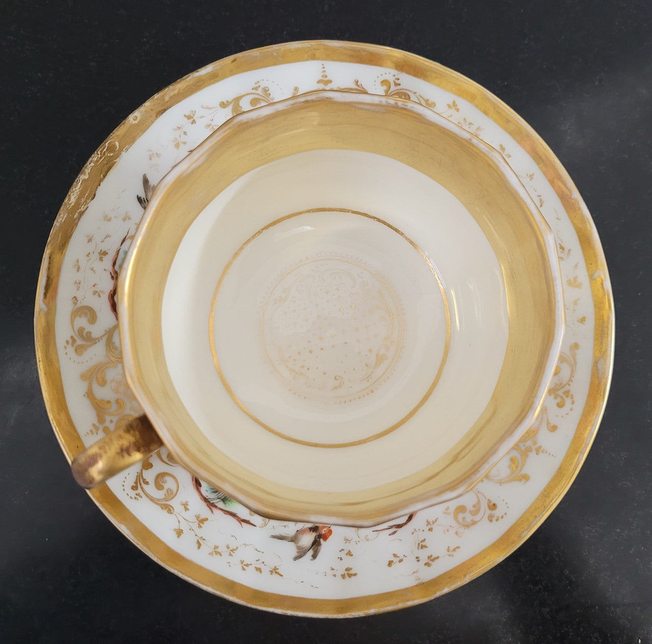 “Old Paris Porcelain” large cup and saucer, beautifully decorated with birds, grapes, floral sprays and heavily gilded. Dated to base 1835. In good original condition please view photos as they help form part of description.
