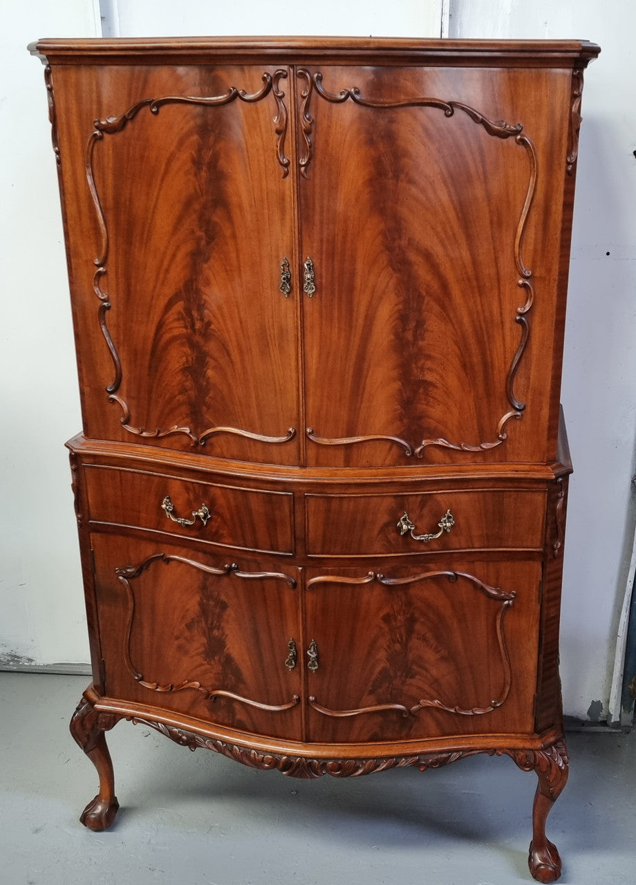 1950’s Chippendale Style Flame Mahogany Four door Bar. The top section has glass shelves and a mirrored pull out tray for storing glasses, decanters & serving etc. It also has a silver presentation plaque to the Mayor of Hawthorn 1958. The bottom section is for storage bottles etc. A stunning and practical piece.