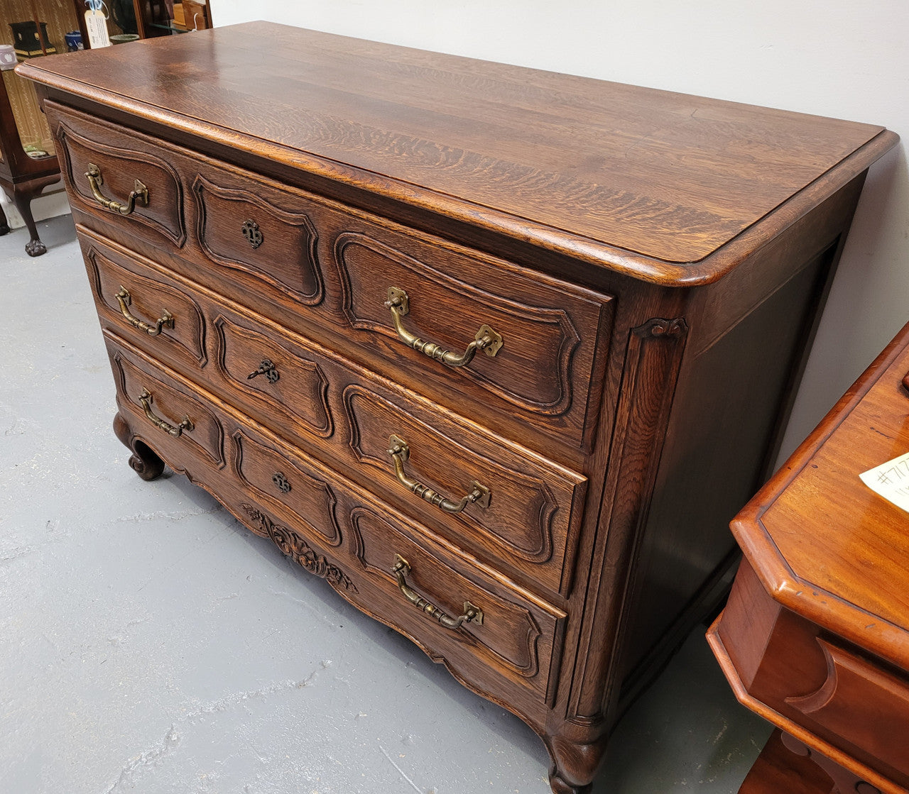 French Provincial Oak three drawer wooden top commode. It has elegant carvings and handles. It has been sourced from France and is in good original detailed condition.