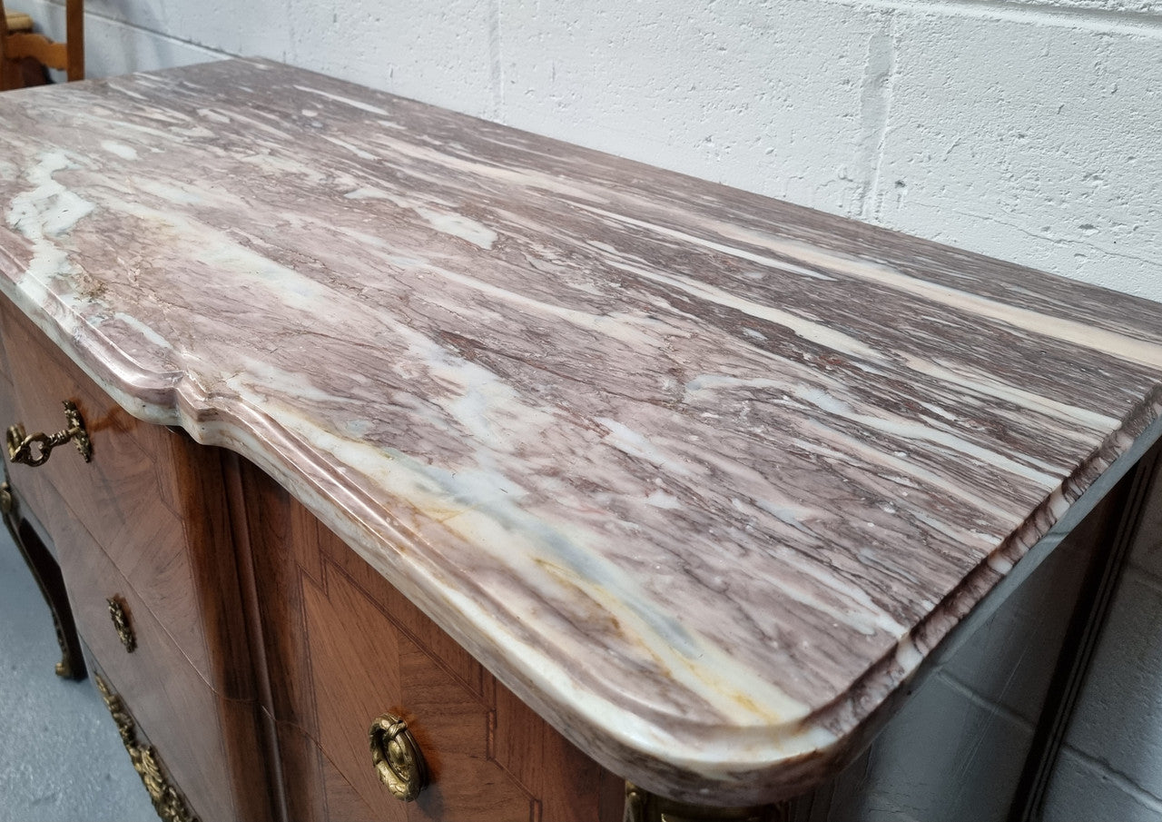 A stunning French transitional Louis XV and Louis XVI style commode. It has beautiful walnut inlay and a fabulous marble top. Comes with two drawers and fitted with gilt brass mounts. it is In very good original condition.