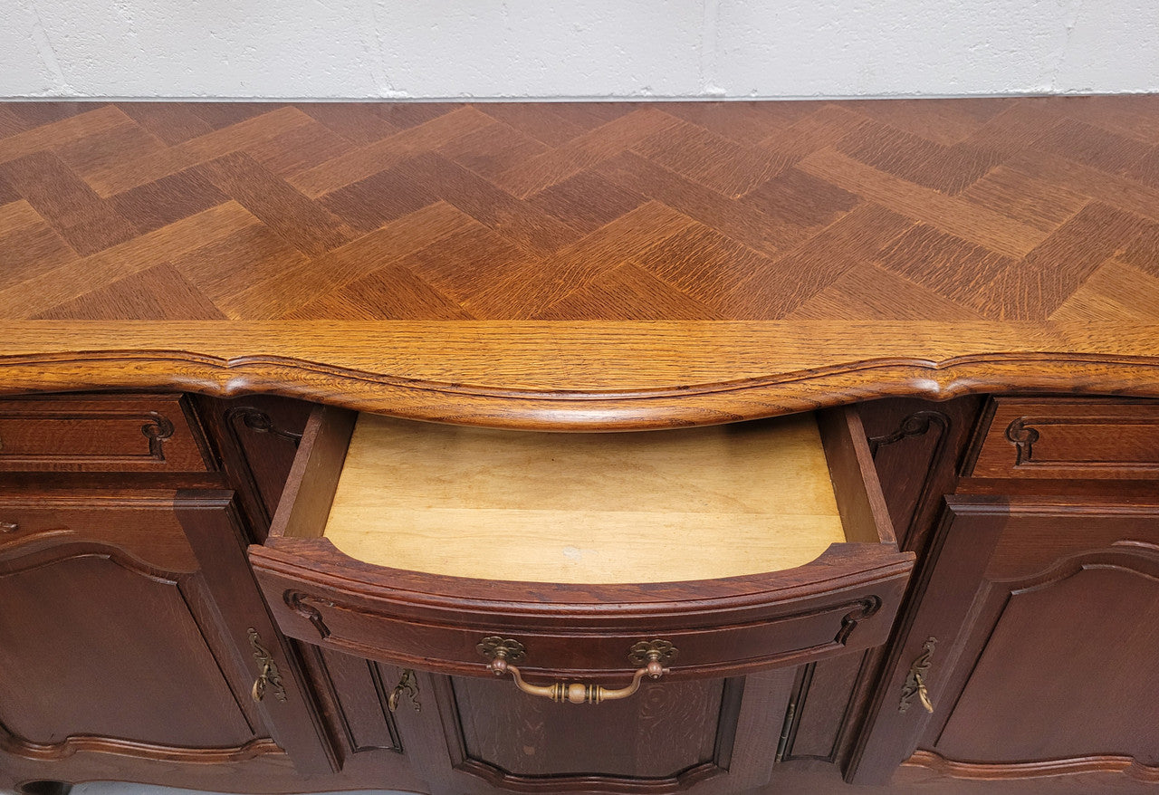 French Oak Louis XV style three drawer three door parquetry top sideboard. It has been sourced from France and is in good original detailed condition.