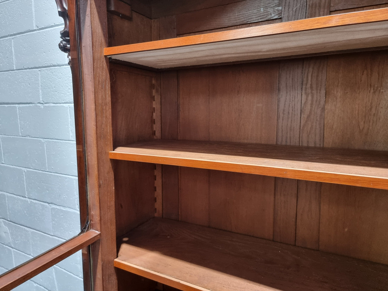 Antique Mahogany two door Biedermeier style bookcase with four fully adjustable shelves and a drawer at the bottom. The two wooden finials at the top are easily removed for a different look of desired. In good original detailed condition.