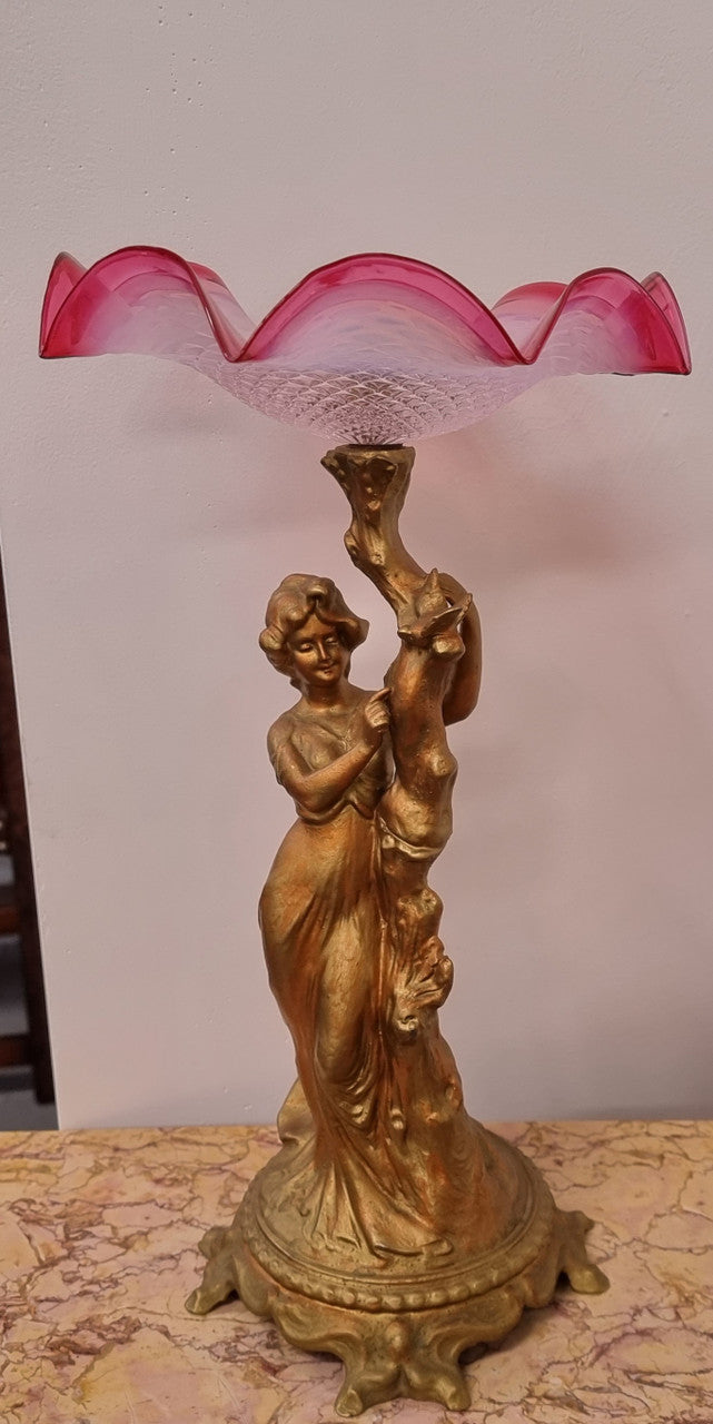 Late Victorian spelter table Centerpiece/comport featuring a woman holding an opalescent and ruby glass bowl. In good original condition with no damage to the ruby bowl.