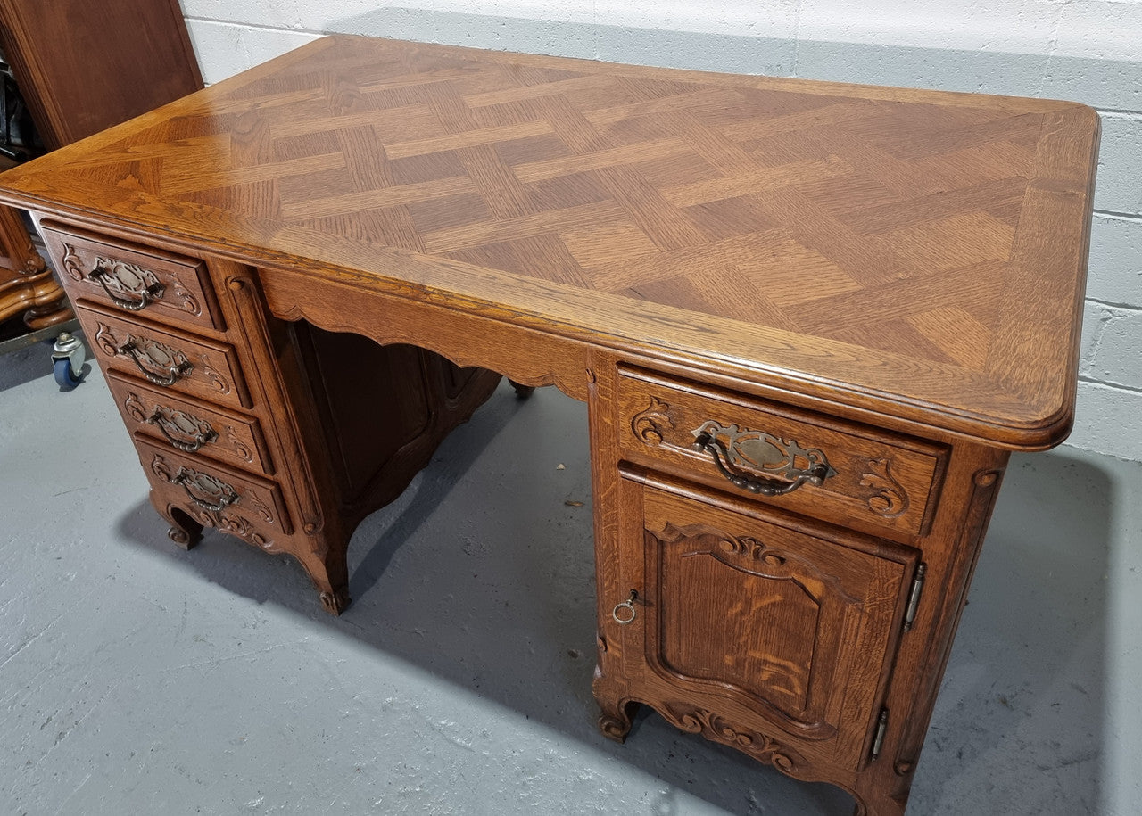 Beautifully carved french oak, faux partners desk with a lovely parquetry top and 6 drawers and 1 cupboard . In good original condition.