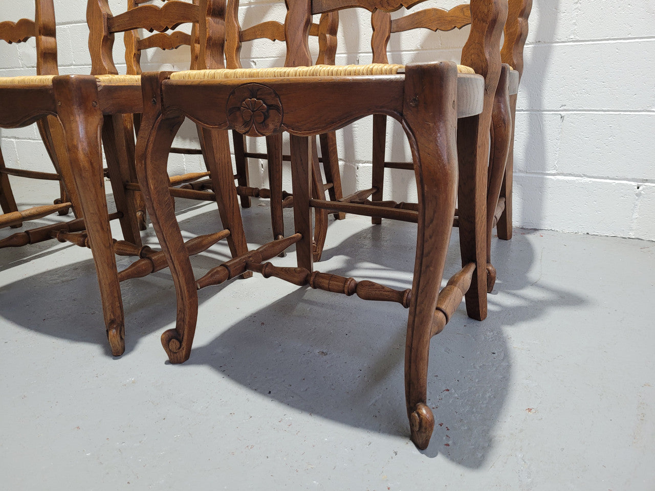 A stunning set of six French Louis XV Style oak dining chairs with rush seats in good original condition. All chairs have been detailed and re-glued where needed.