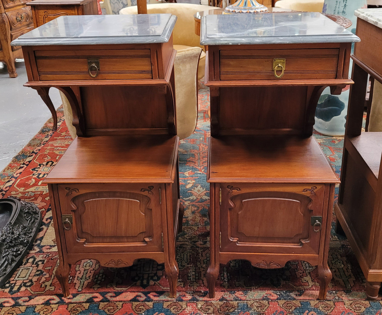 Pair of unusual transitional fruit wood marble top bedside cabinets. They have been sourced from France and are in good original detailed condition.