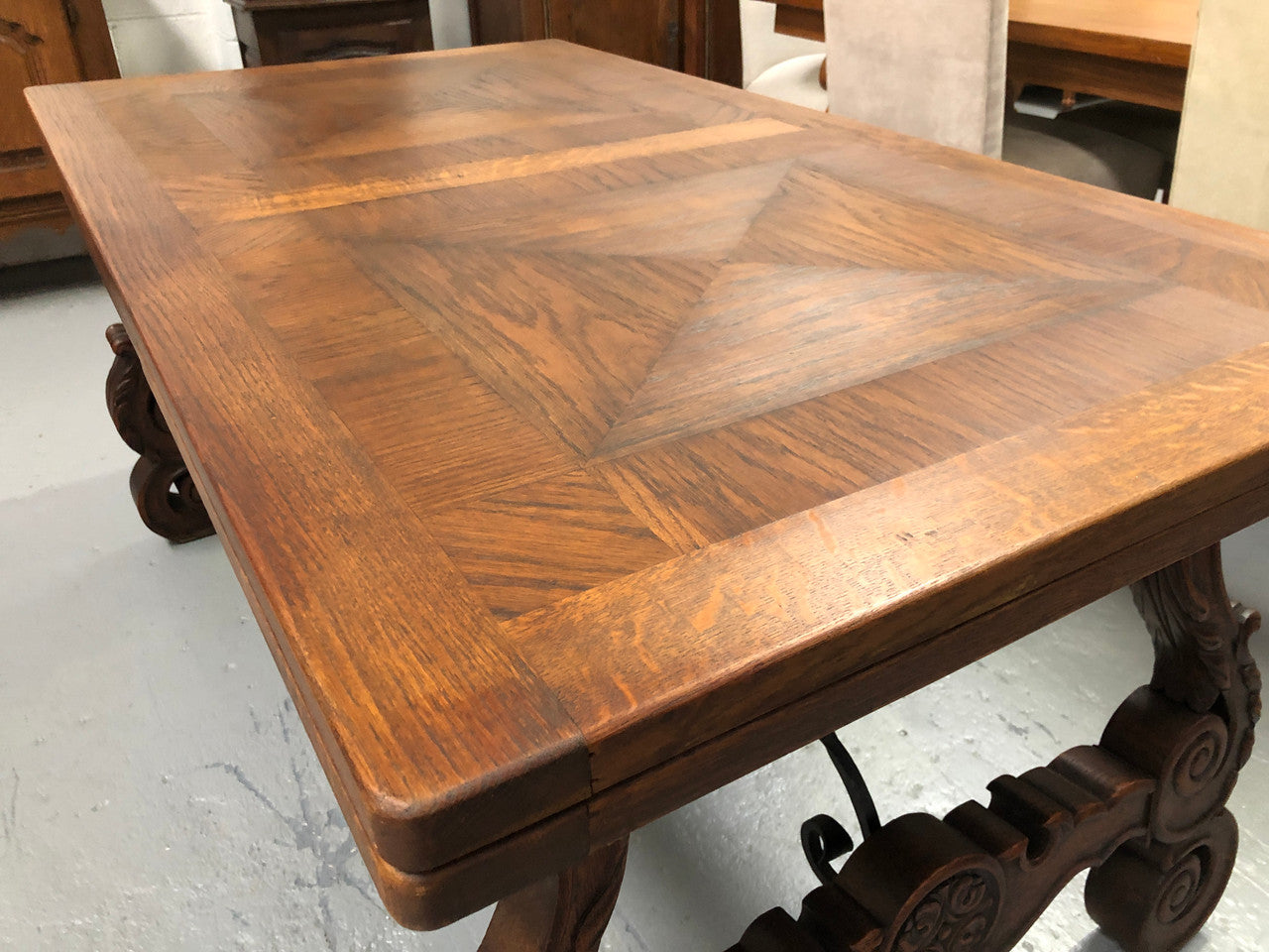 French Oak Renaissance style extension table with a lovely parquetry top and decorative carved and iron base in good original detailed condition.