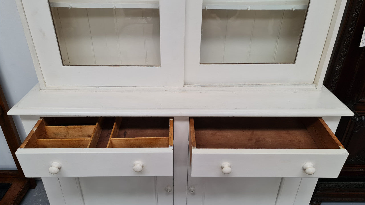 Australian painted two door kitchen hutch display and buffet cabinet. The top section has hooks and shelves. The bottom has two drawers along with cupboard space for added storage. In good original condition.