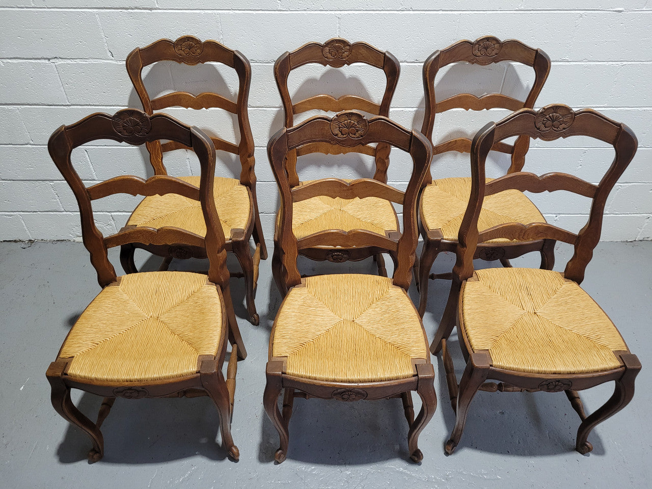 A stunning set of six French Louis XV Style oak dining chairs with rush seats in good original condition. All chairs have been detailed and re-glued where needed.