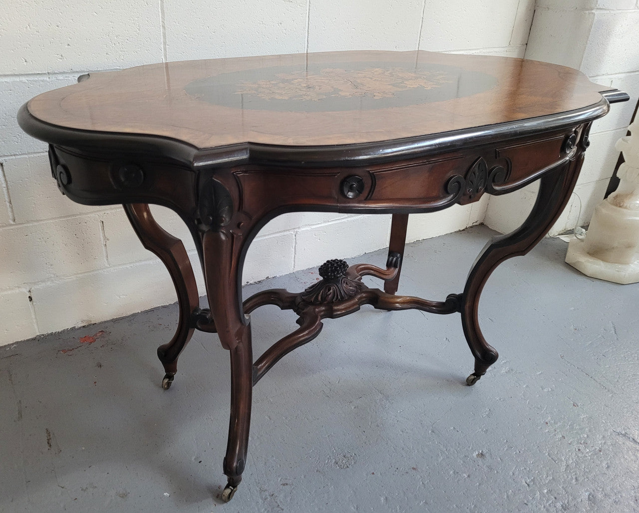 French Napoleon III style centre table. Made from Rosewood and figured Walnut and is beautifully inlaid with an ebonized edge. It has an attractive carved undercarriage and single drawer. In good original detailed condition.