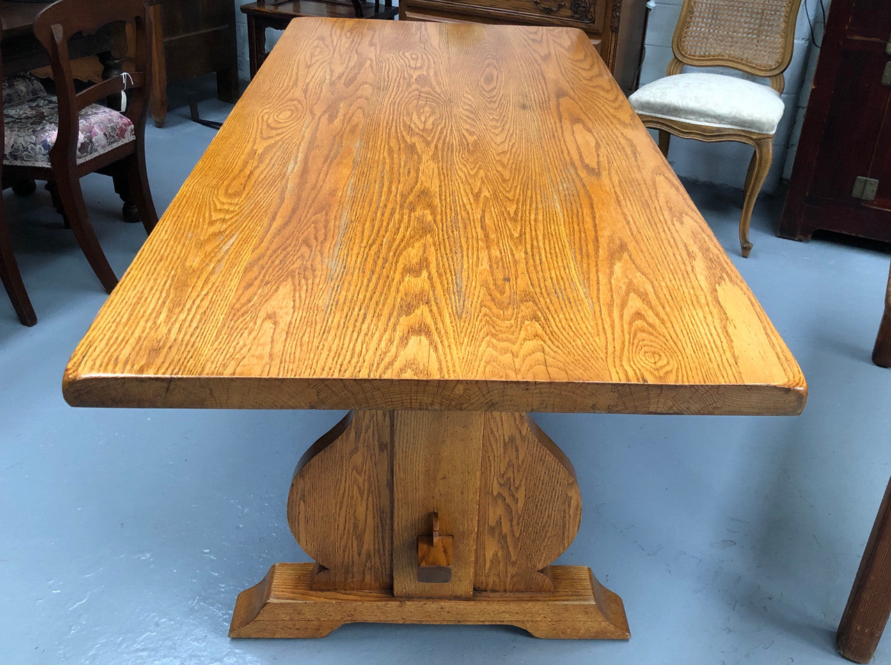 A French Style Oak stretcher base table with amazing wood grain. Can comfortable sit 6-8 people and is in original detailed condition.