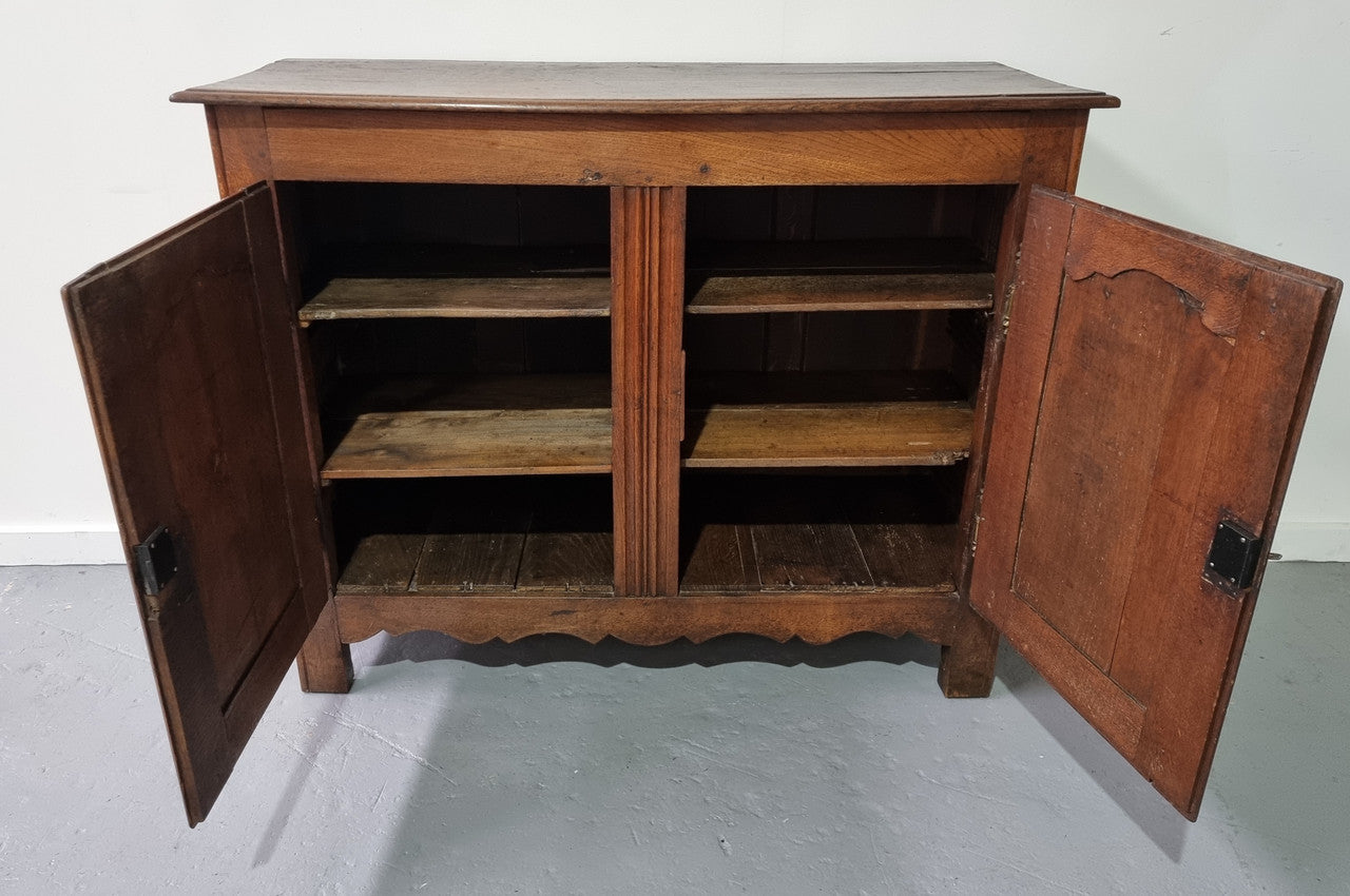A charming French Oak early 18th Century two door sideboard. Plenty of storage space with two fixed shelves either side. It is in good original detailed condition for its age and comes with a working key and working locks.