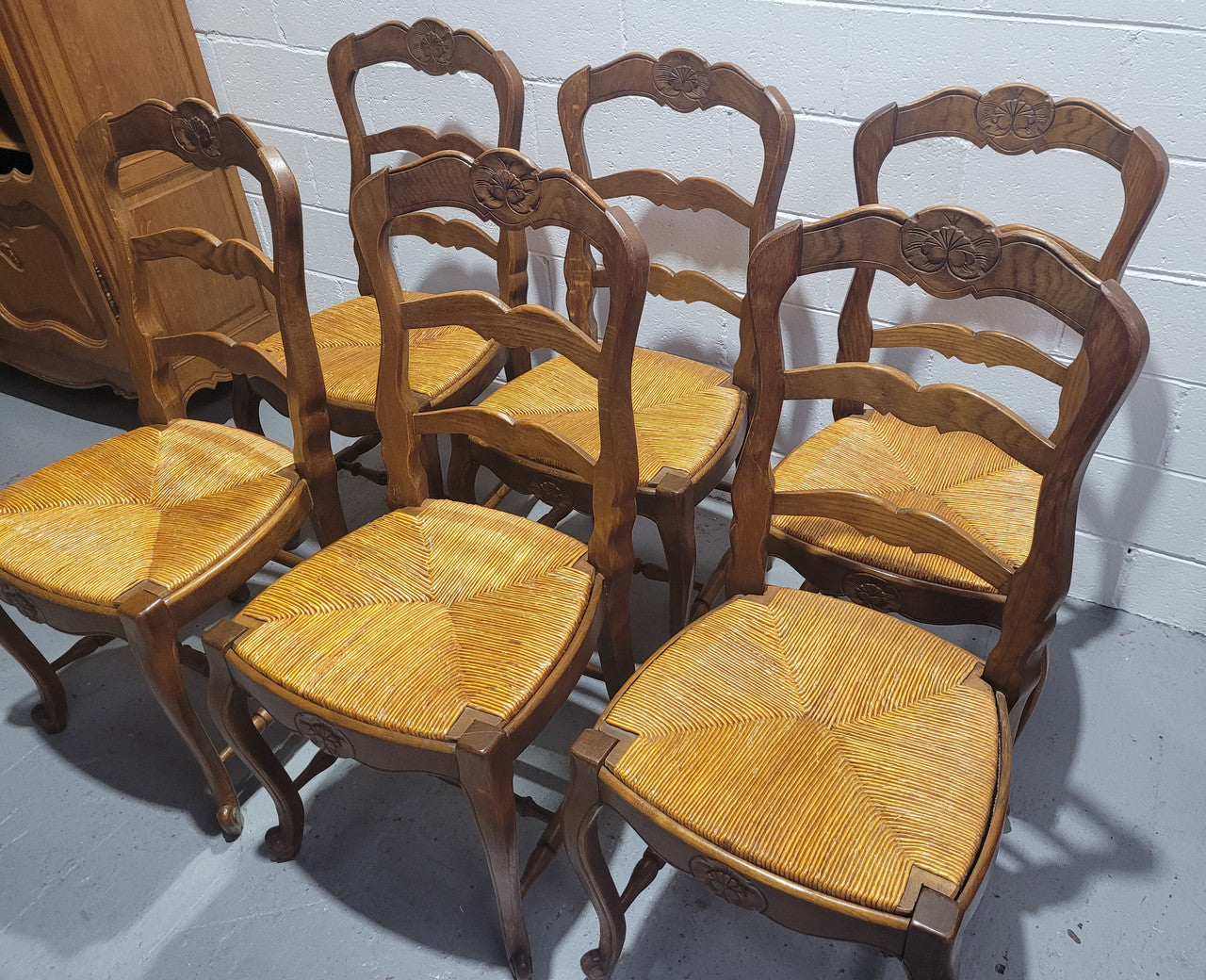 Set of six French Louis 15th style rush seated dining chairs. They are comfortable to sit in and are in original condition.