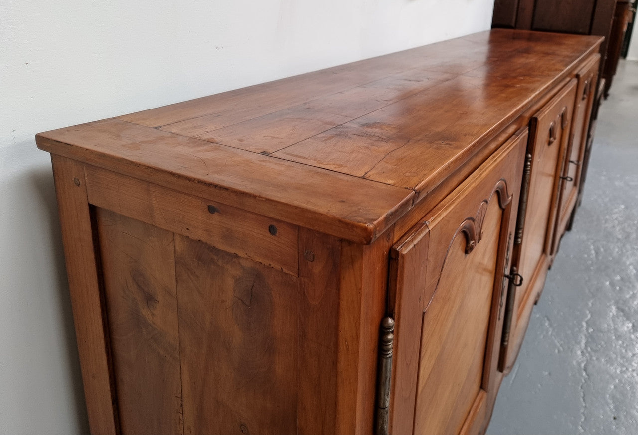 Early 19th Century Louis XV style Fruitwood three door sideboard. It has three hidden internal drawers and one of them has green valet and small sections for cutlery. It is in good restored condition.