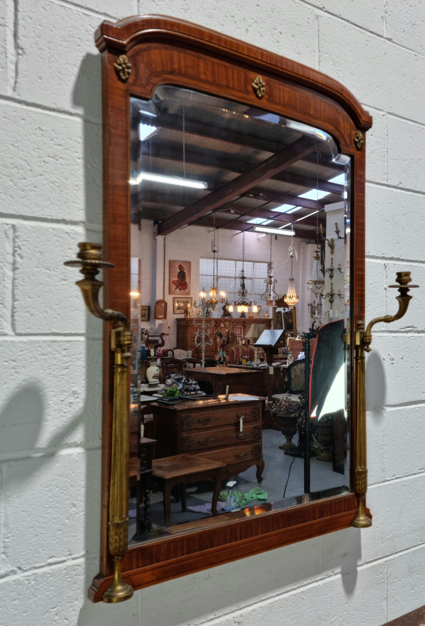 Decorative late 19th Century mahogany French wall mirror with brass swivel candle holders and brass detail. In good original detailed condition.